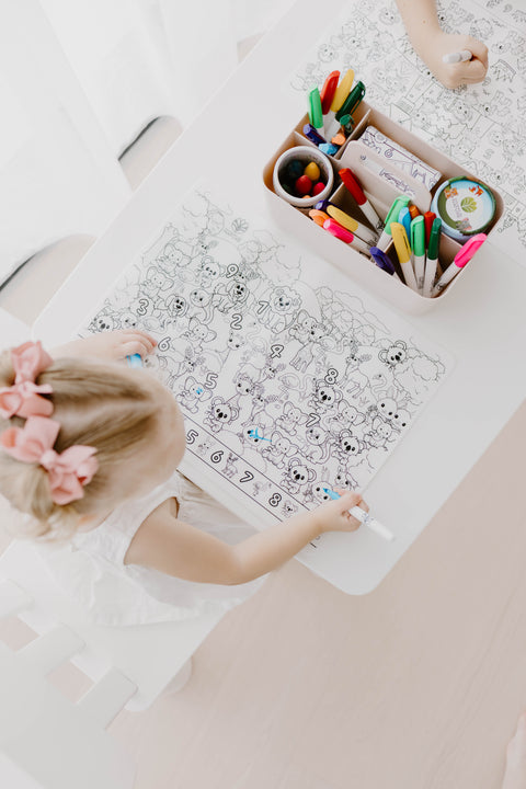 Child colouring princesses and fairies on a Seek n Spot reusable silicone mat